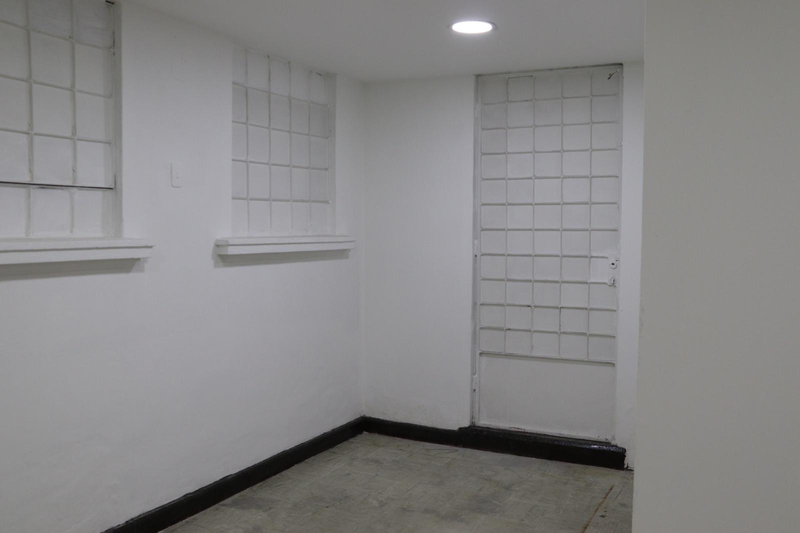 Corner of a white room with glass-block windows and a glass-block door