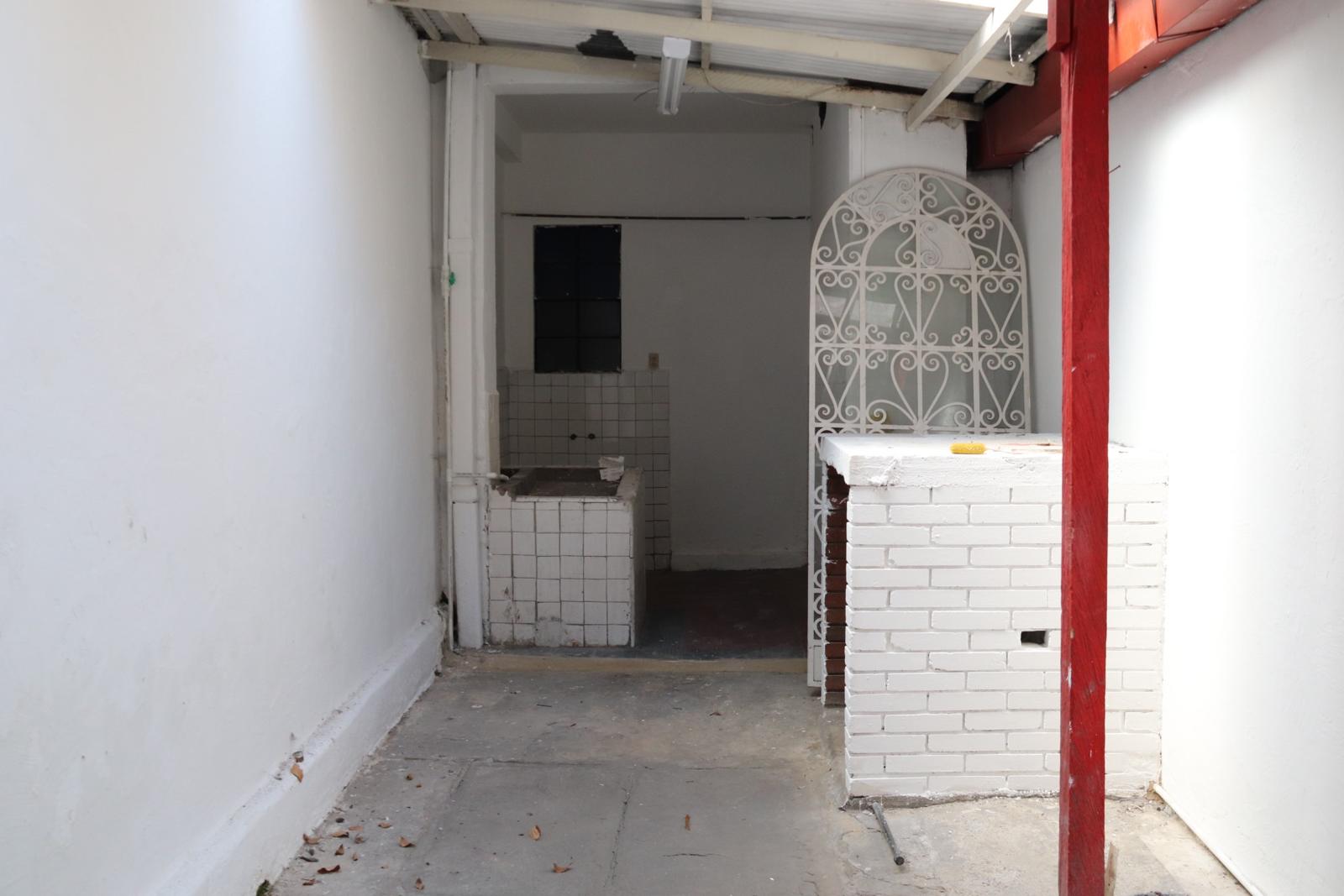 Covered interior patio with white brick counter and a wrought-iron arched screen