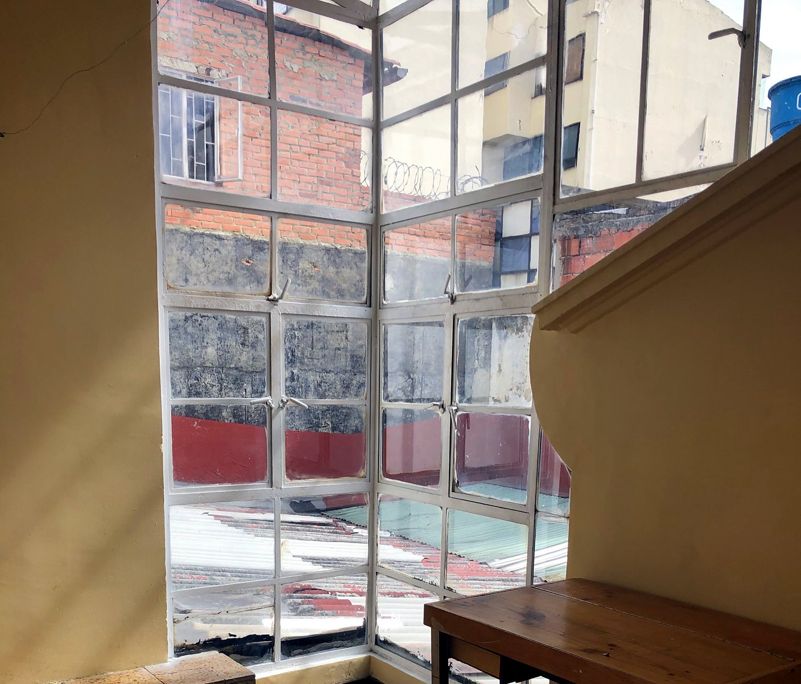 Terrazzo landing lit by a steel-framed corner window
