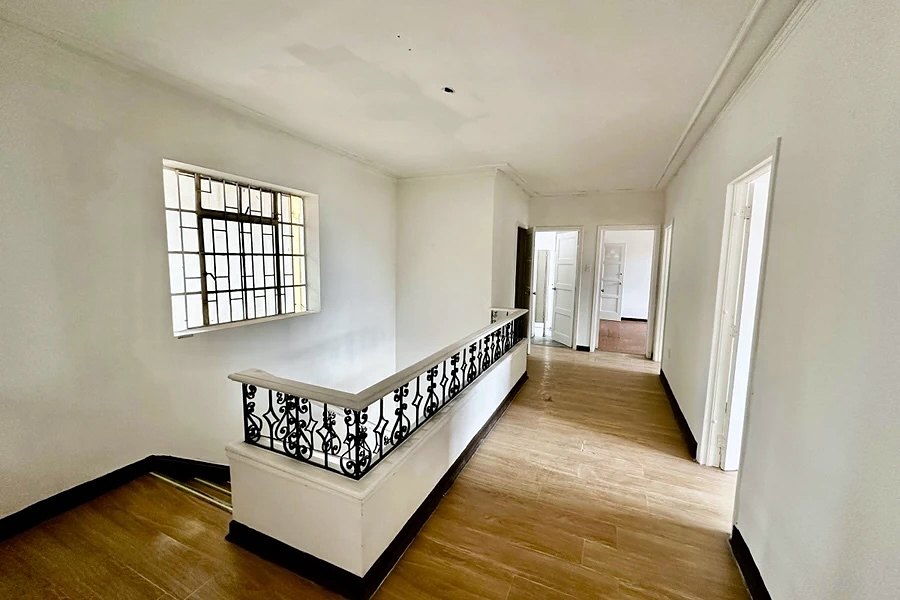 Bright open upper floor with a steel-framed window, iron balustrade and a row of doors